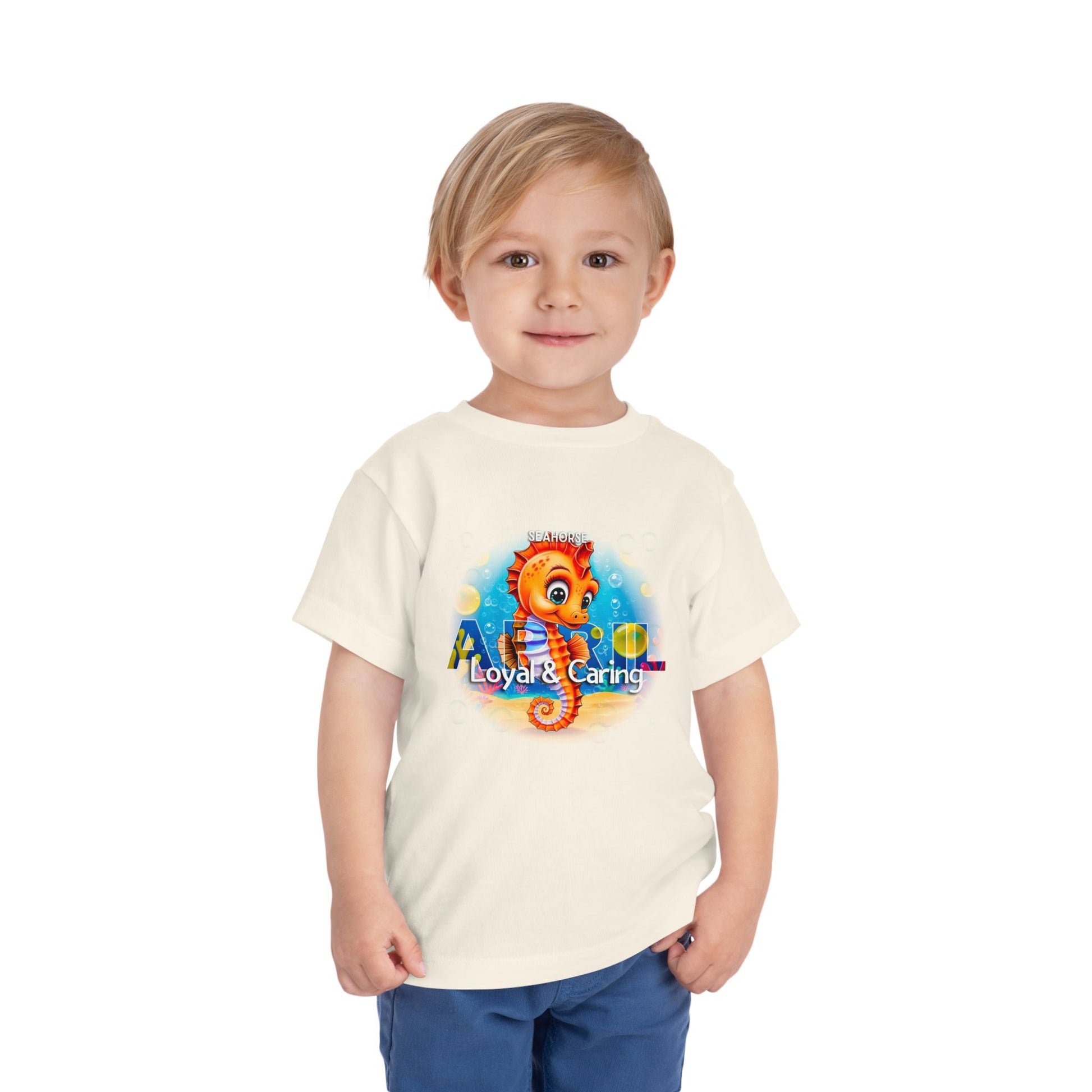 Toddler wearing a kids birth month tshirt featuring a colorful seahorse design with loyal and caring traits
