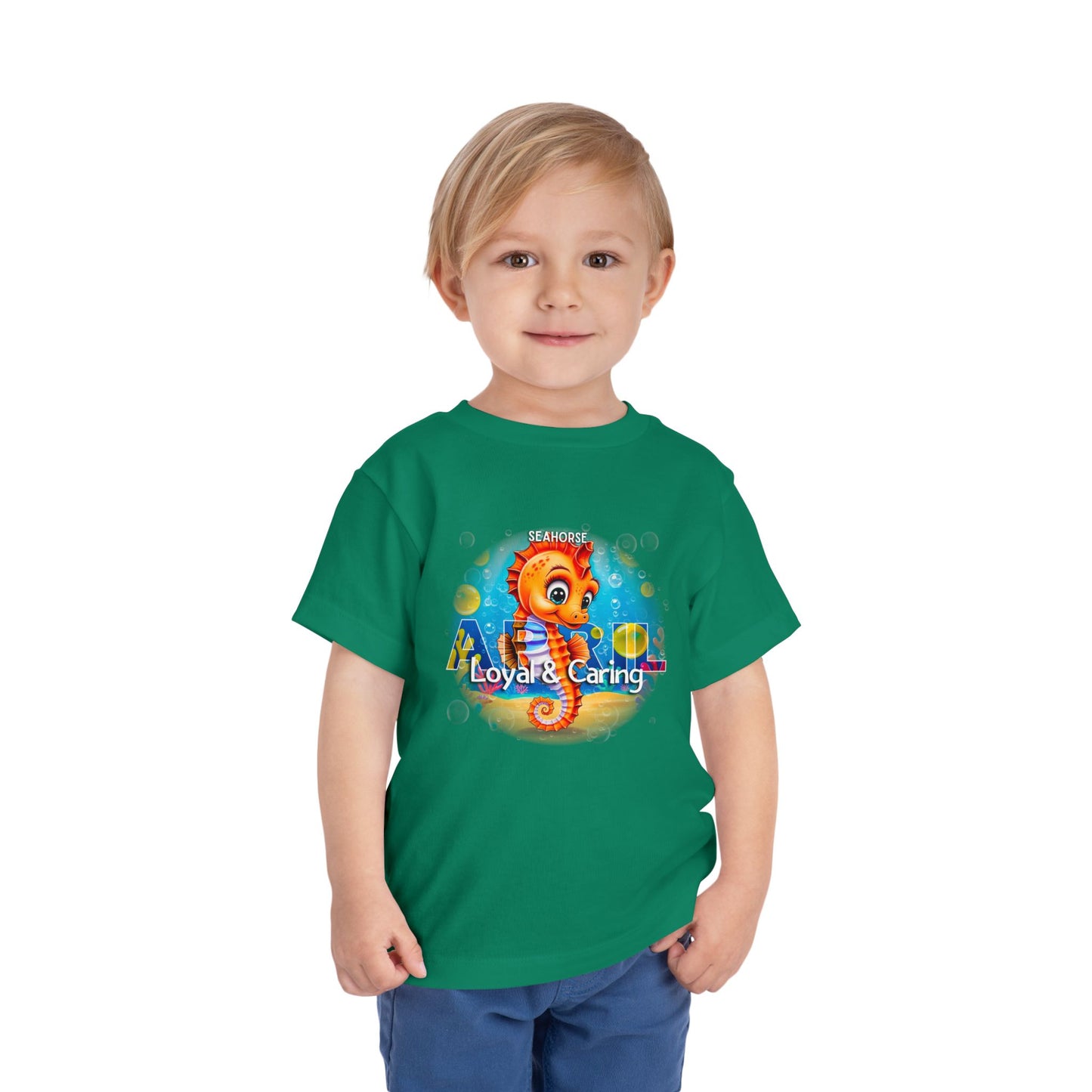 Green kids birth month tshirt with cute seahorse design labeled Loyal and Caring on a smiling toddler
