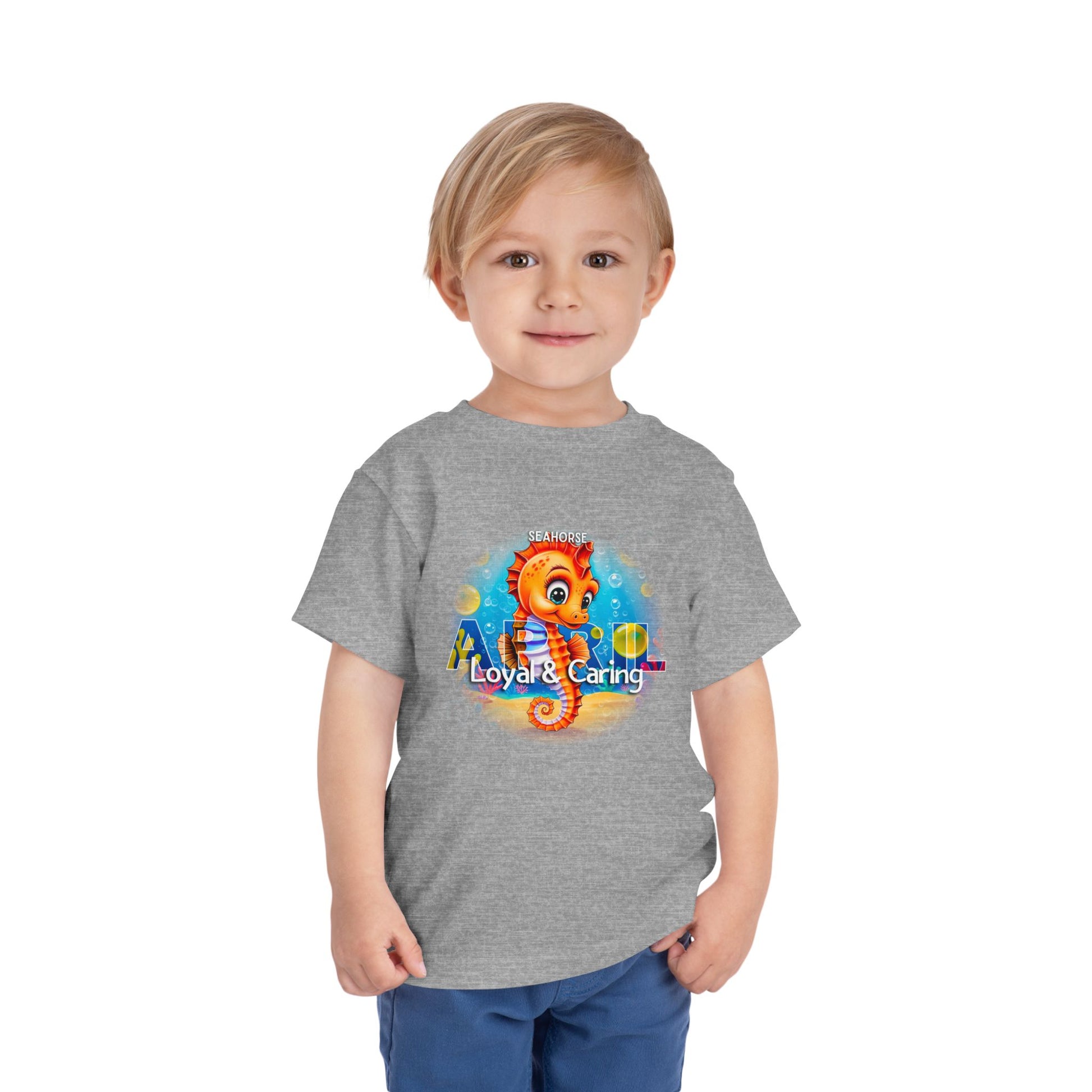 Toddler wearing gray kids birth month tshirt featuring a colorful seahorse design