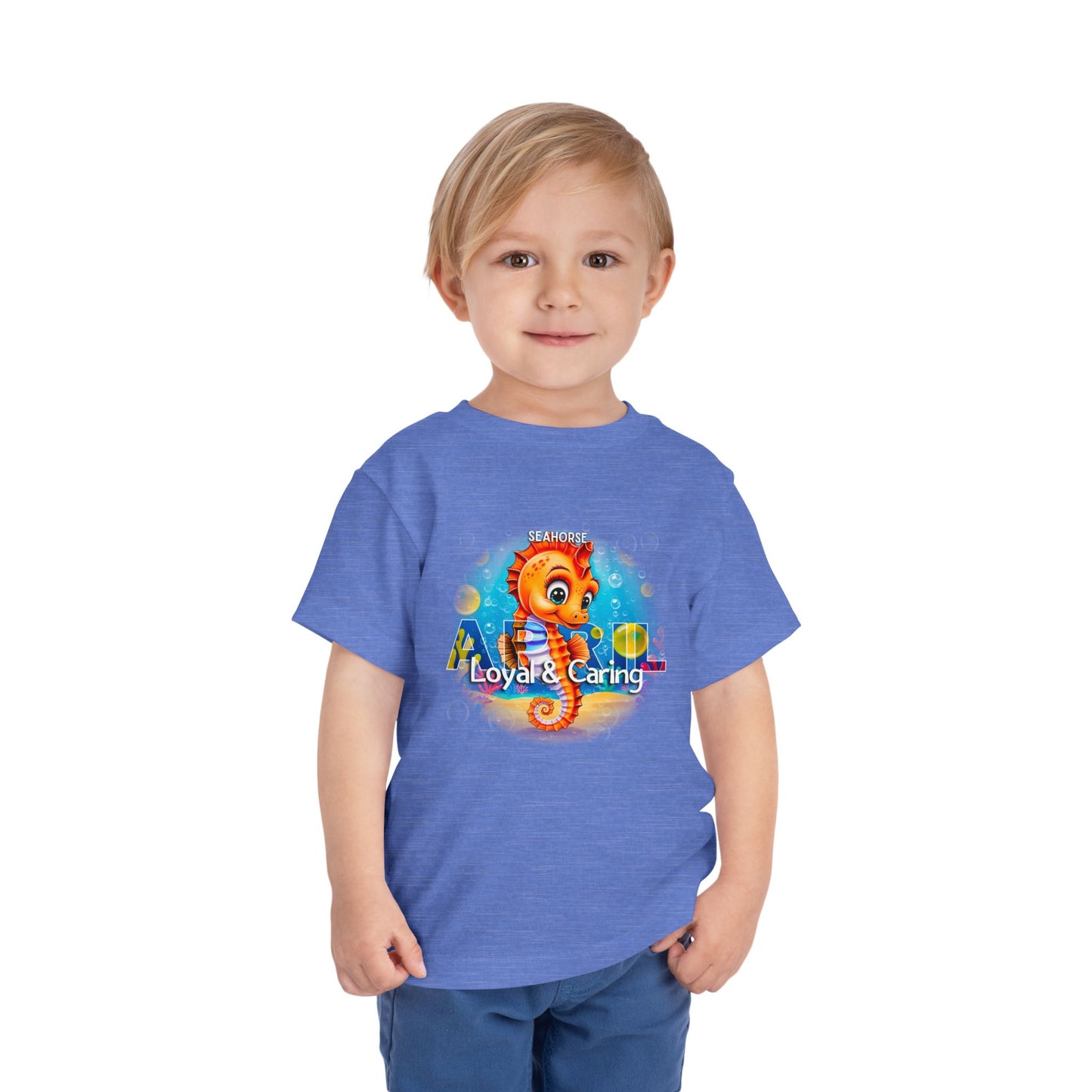 Toddler wearing blue kids birth month tshirt with seahorse design and loyal caring text