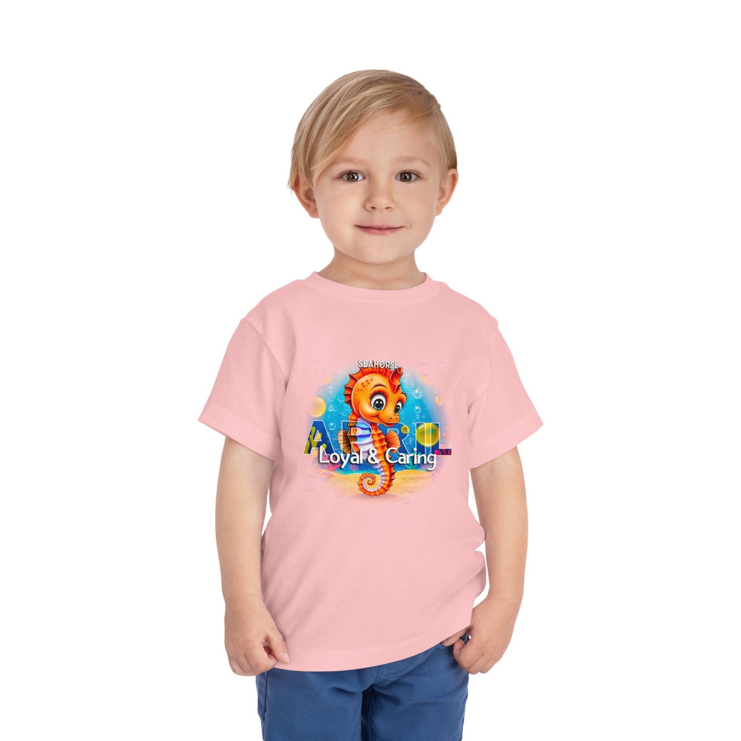 Toddler wearing pink kids birth month tshirt with colorful seahorse design loyal and caring theme