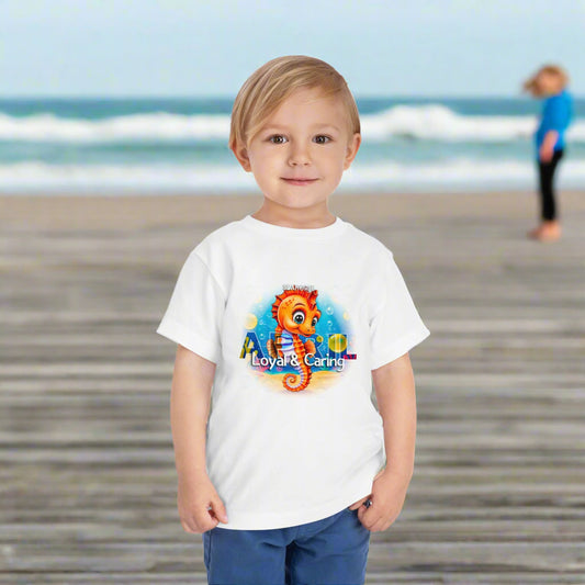 Young boy wearing a white kids birth month tshirt with a colorful seahorse design and loyal caring text