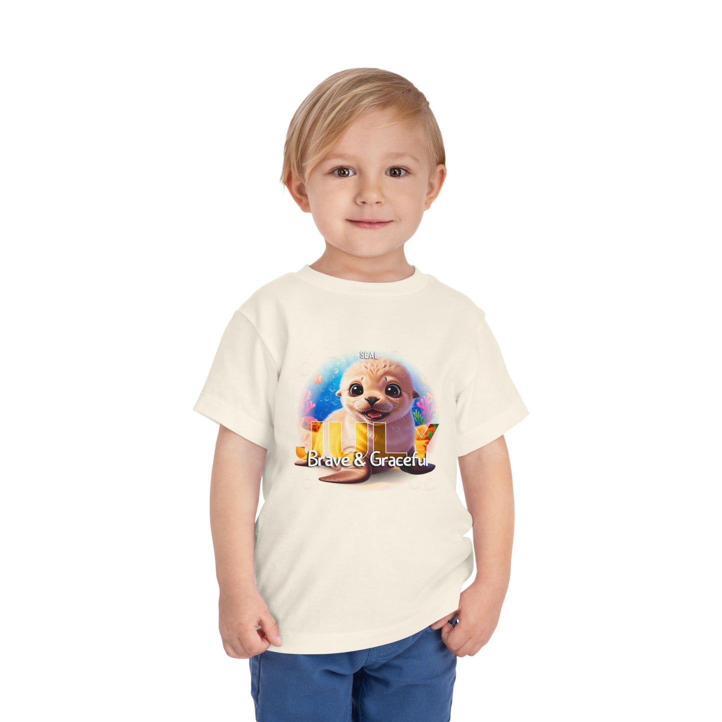 Toddler wearing a kids birth month tshirt with a cute seal and Brave and Graceful text