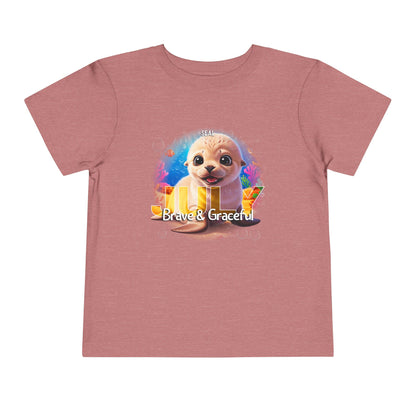 Kids birth month tshirt featuring a cute seal with Brave and Graceful text on a pink shirt