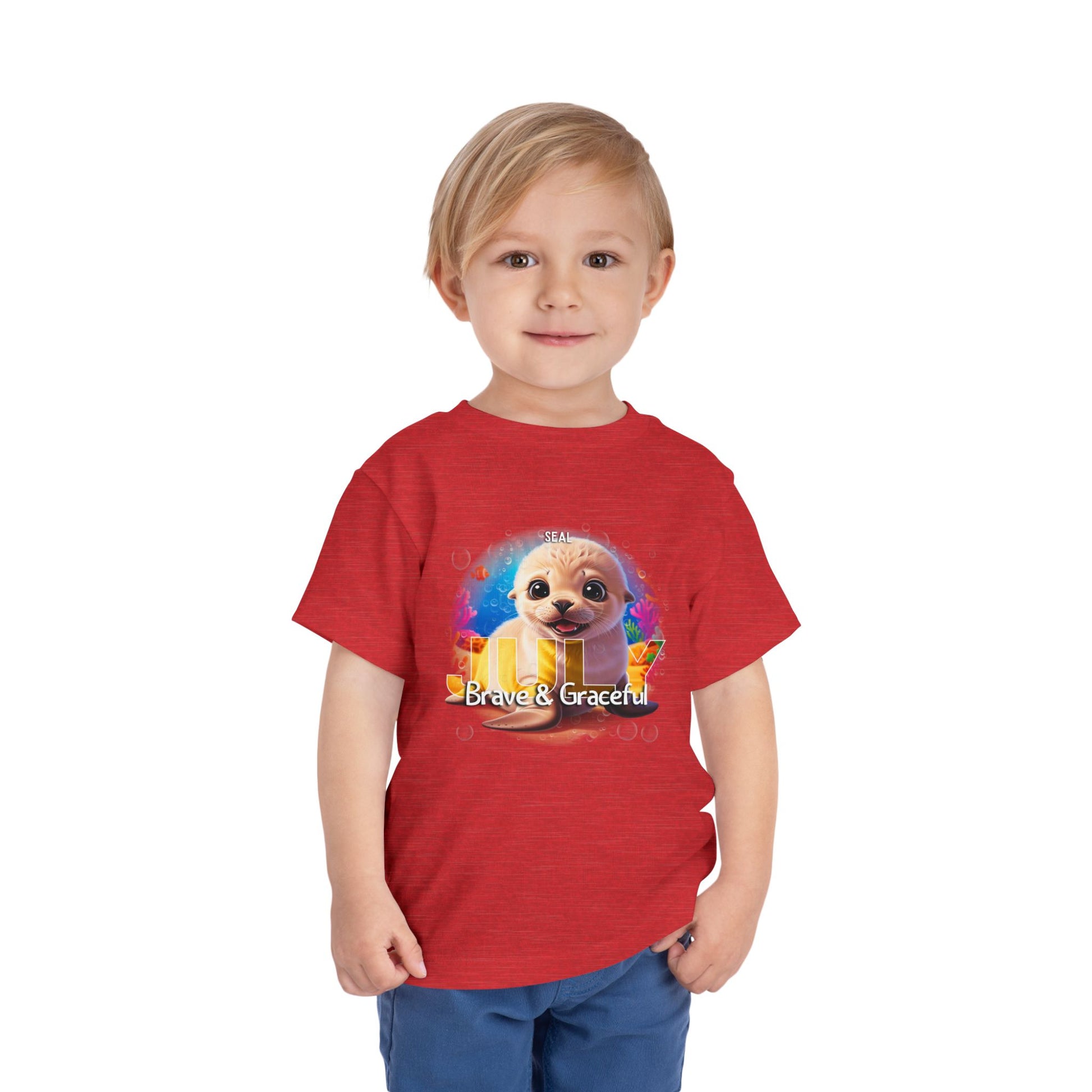 Toddler wearing a red kids birth month tshirt with a cute dog and Brave & Graceful text