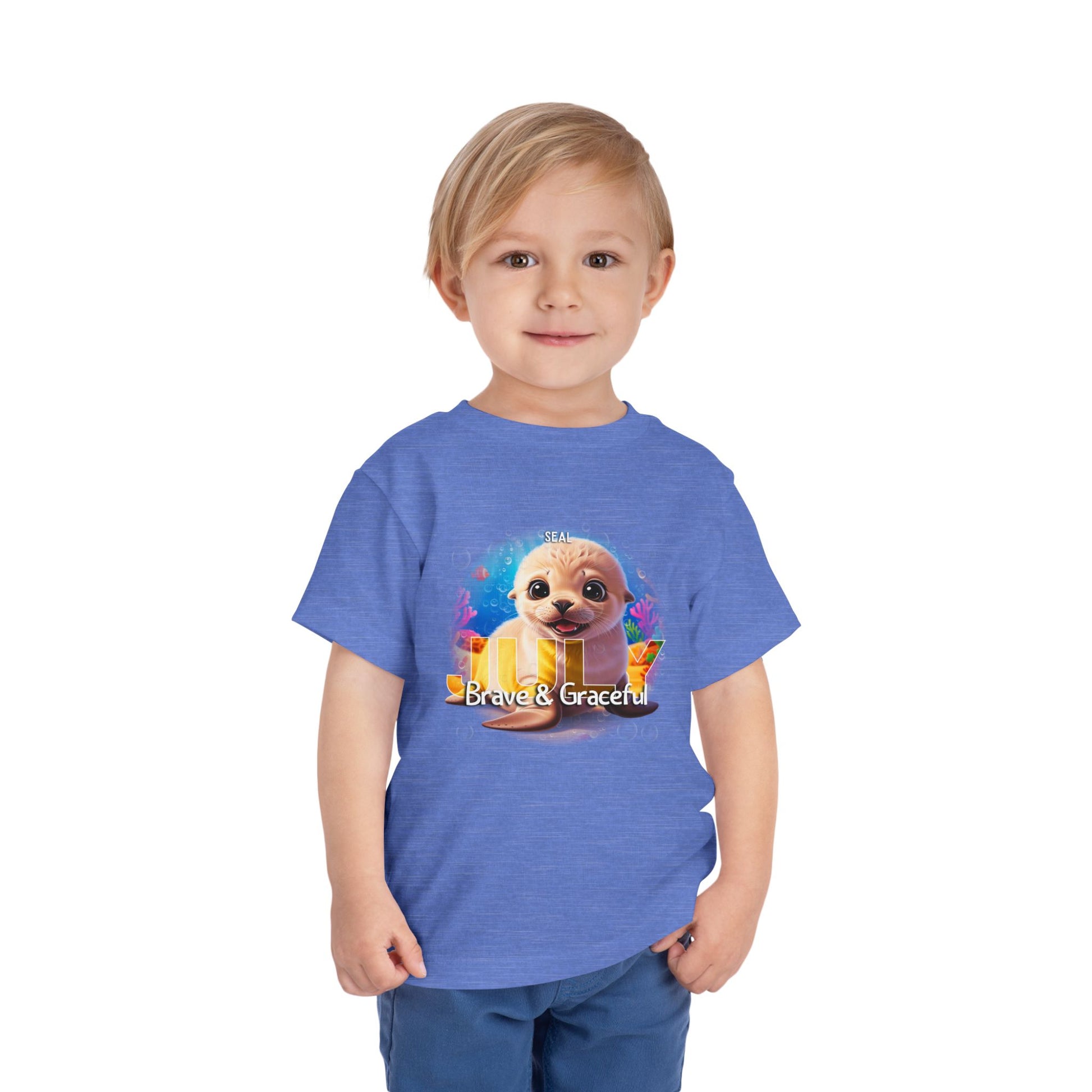 Child wearing blue kids birth month tshirt with a cute seal graphic and Brave & Graceful text
