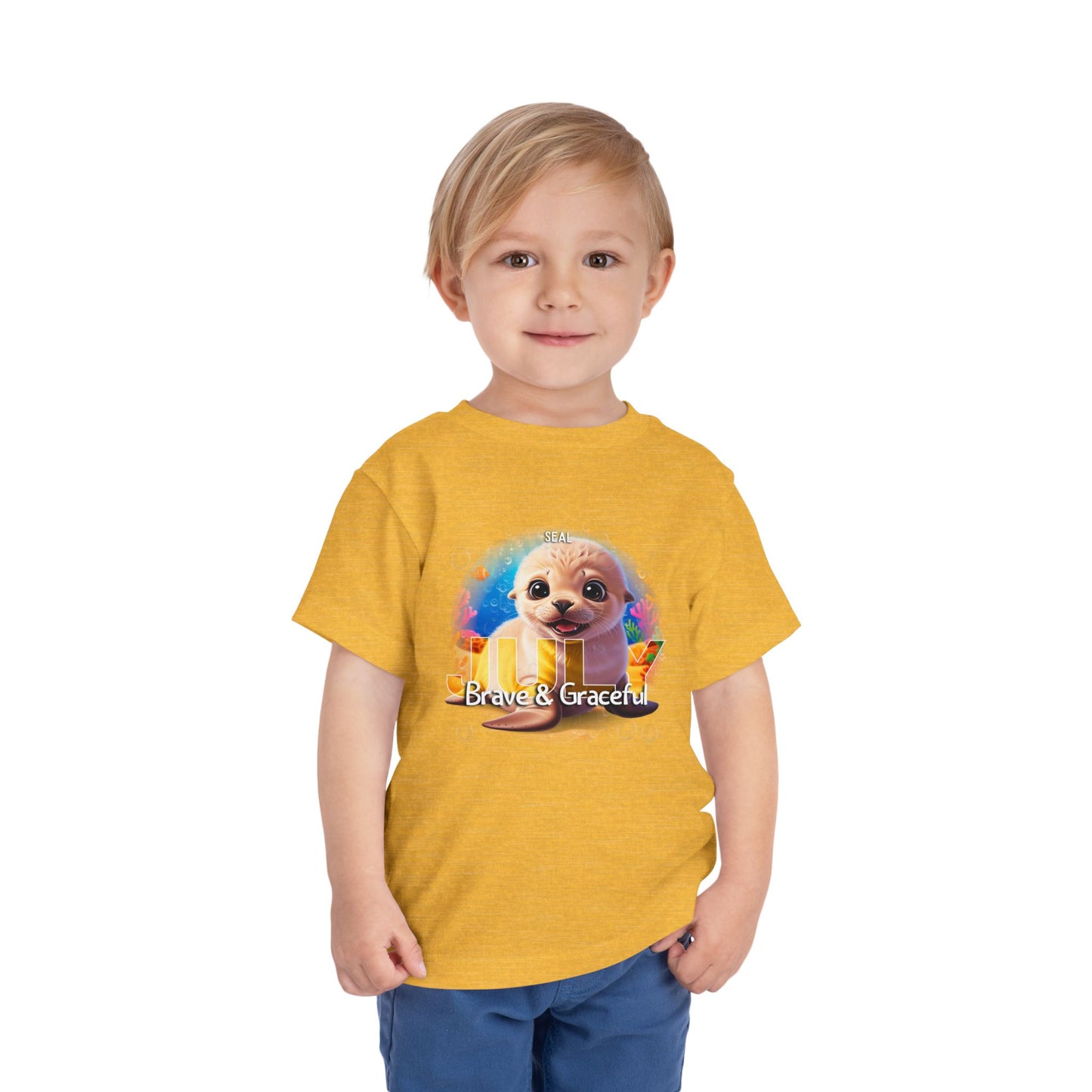 Child wearing a yellow kids birth month tshirt with a cute seal and text Brave & Graceful