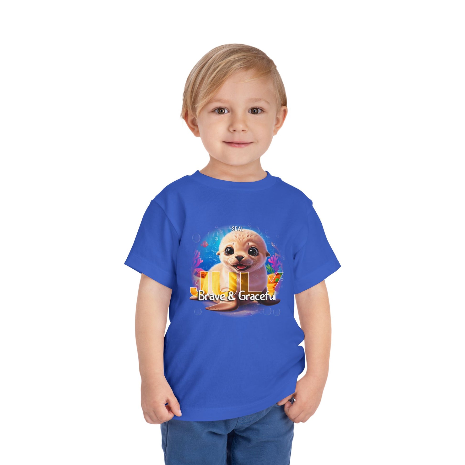 Child wearing blue kids birth month tshirt with a cute seal and Brave & Graceful text design