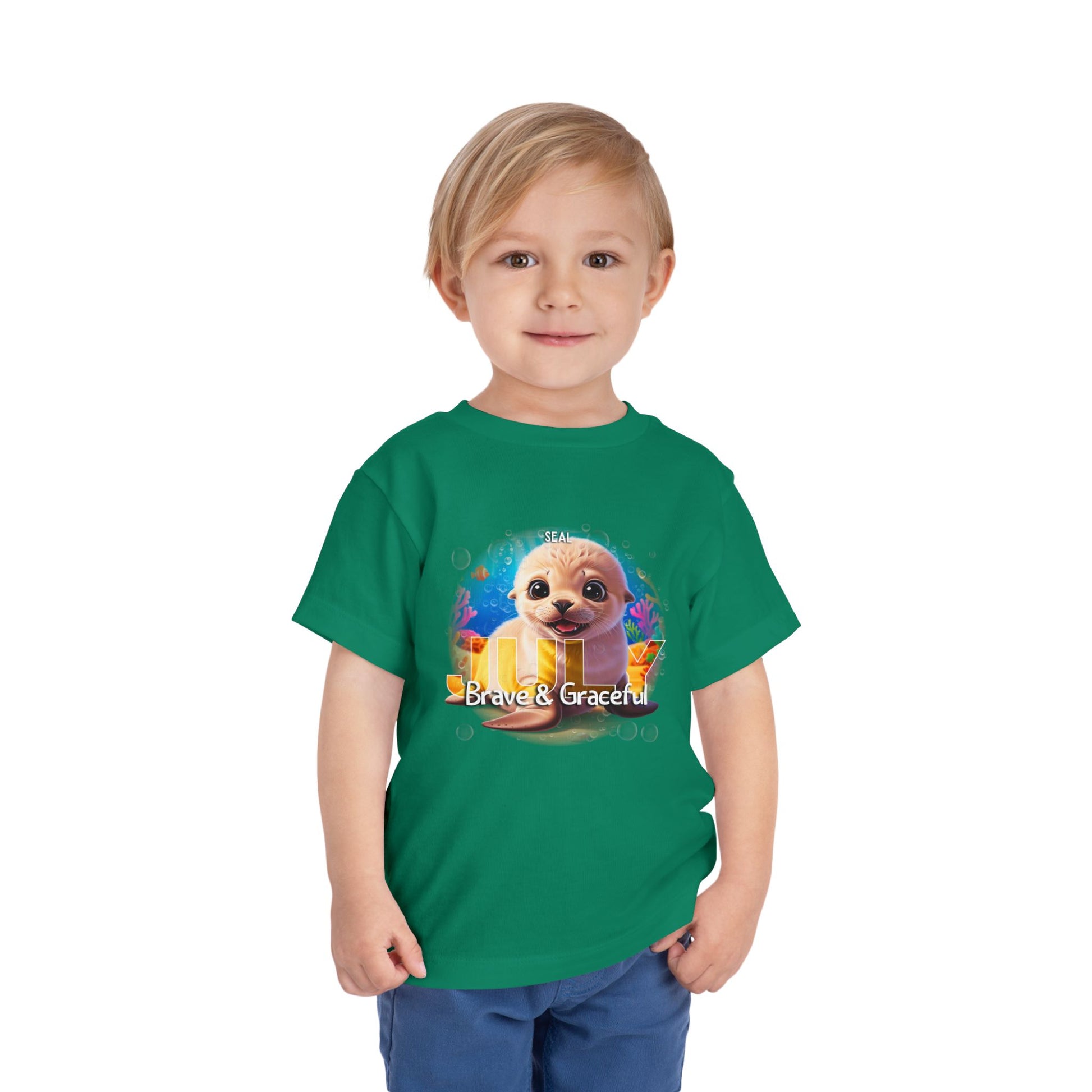 Child wearing green kids birth month tshirt with a cute seal and text Brave & Graceful