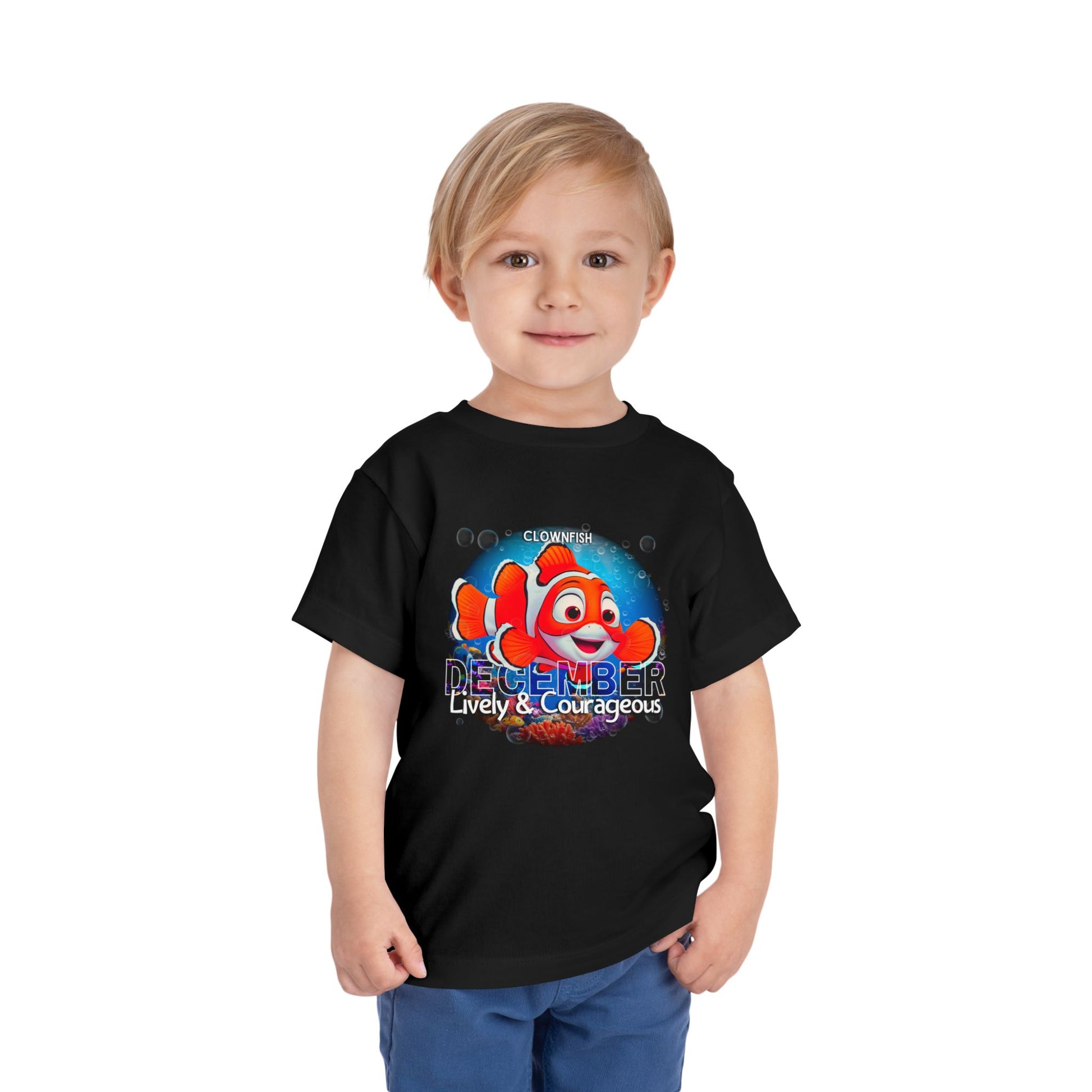 Child wearing a black kids birth month tshirt with a colorful clownfish and December design