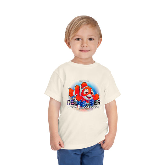 Child wearing a kids birth month tshirt with a colorful clownfish design and December text