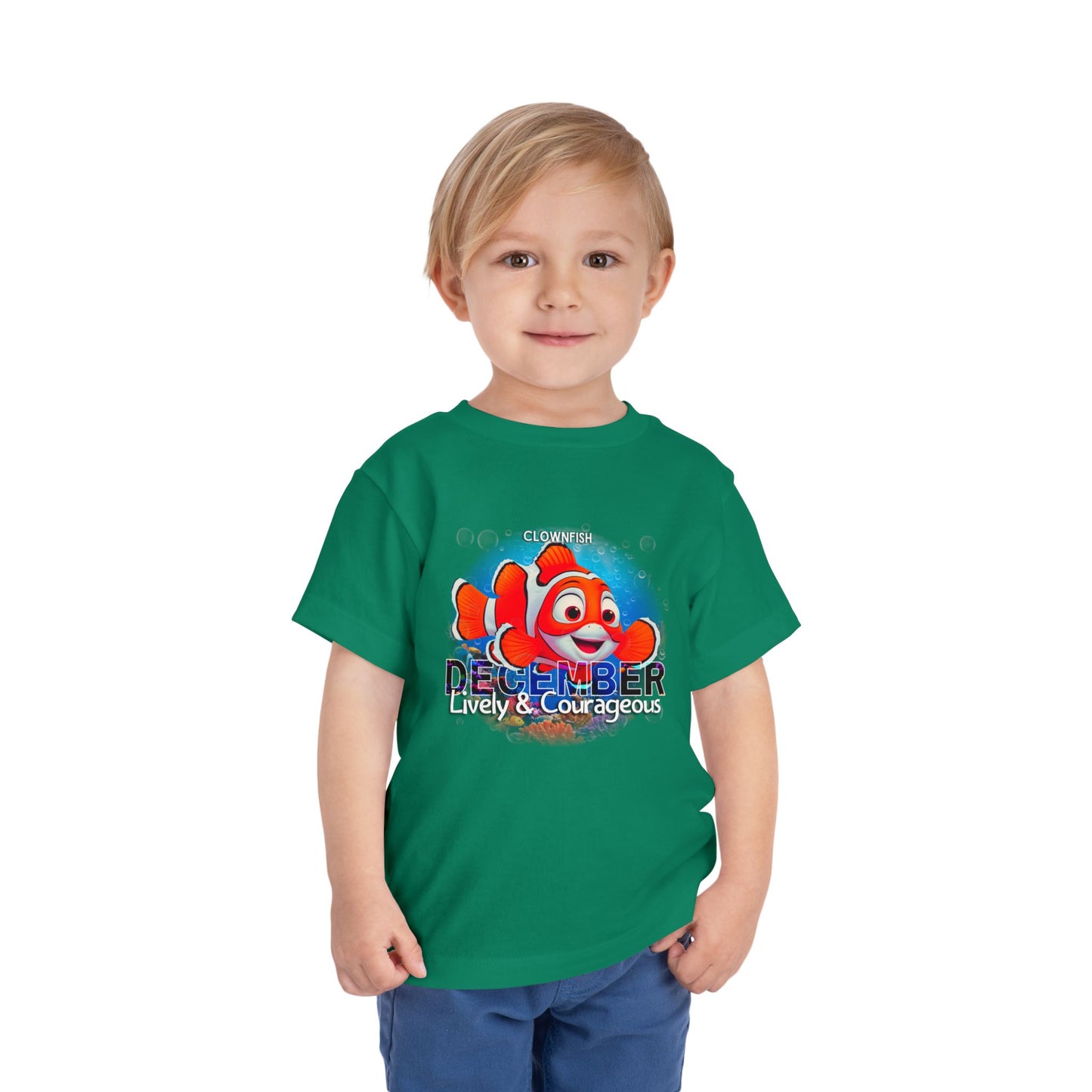 Child wearing green kids birth month tshirt with colorful December clownfish design