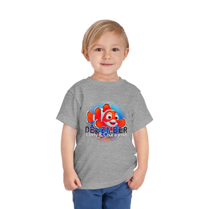 Child wearing a grey kids birth month tshirt with colorful December clownfish design 