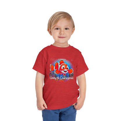 Boy wearing a red kids birth month tshirt with a clownfish and December text design
