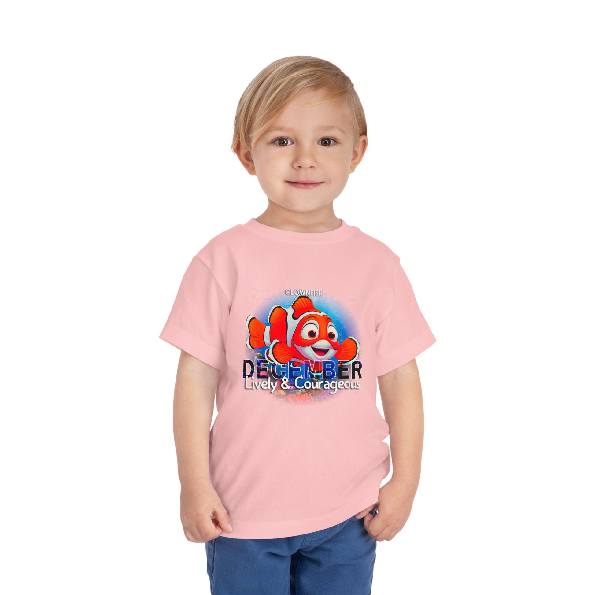 Toddler wearing pink kids birth month tshirt featuring a cartoon clownfish and December text