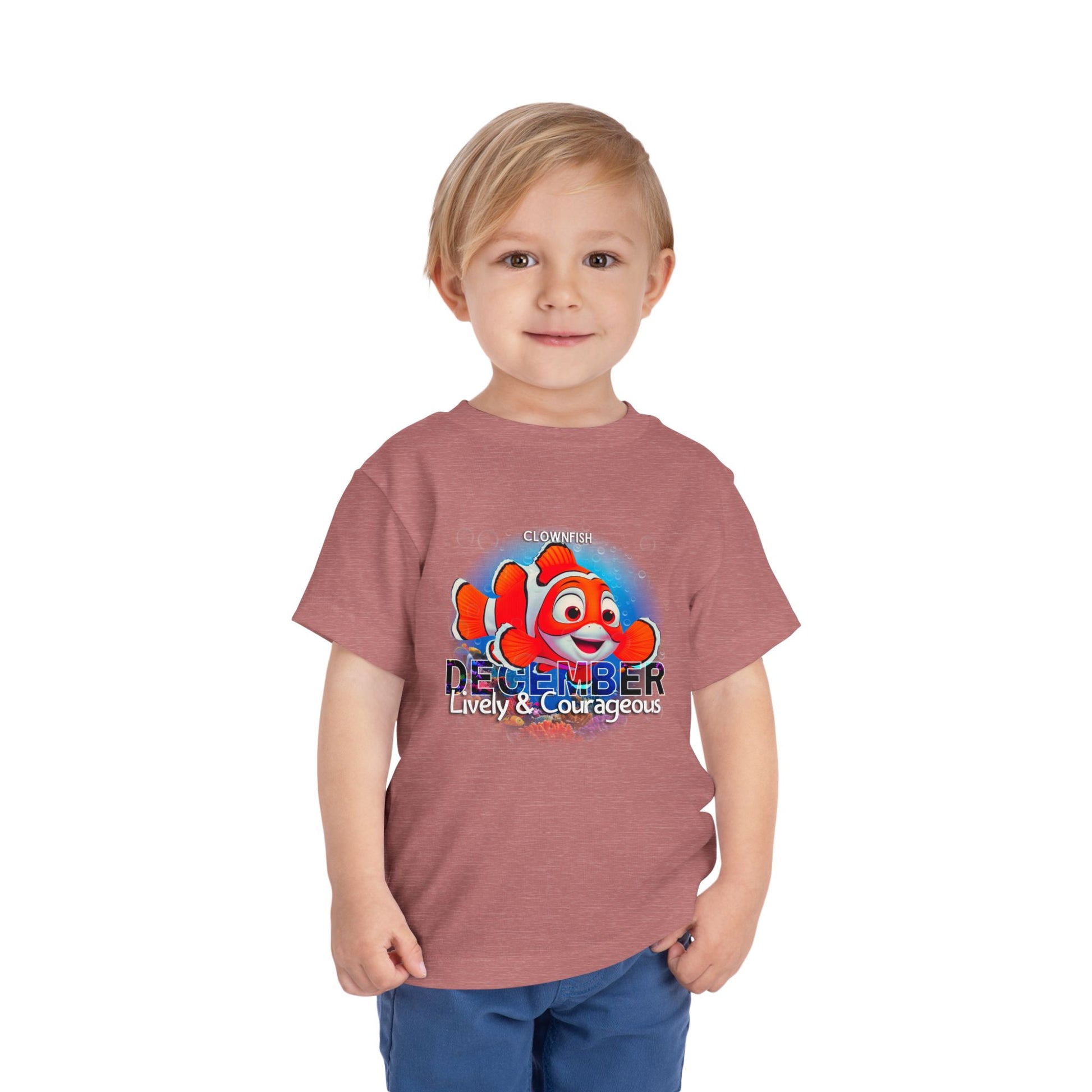 Toddler wearing kids birth month tshirt with December clownfish design in red