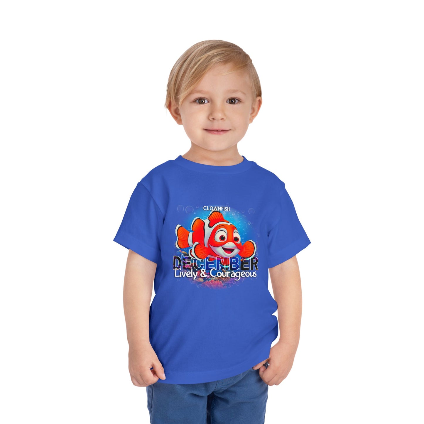 Boy wearing a blue kids birth month tshirt with a clownfish graphic and December text