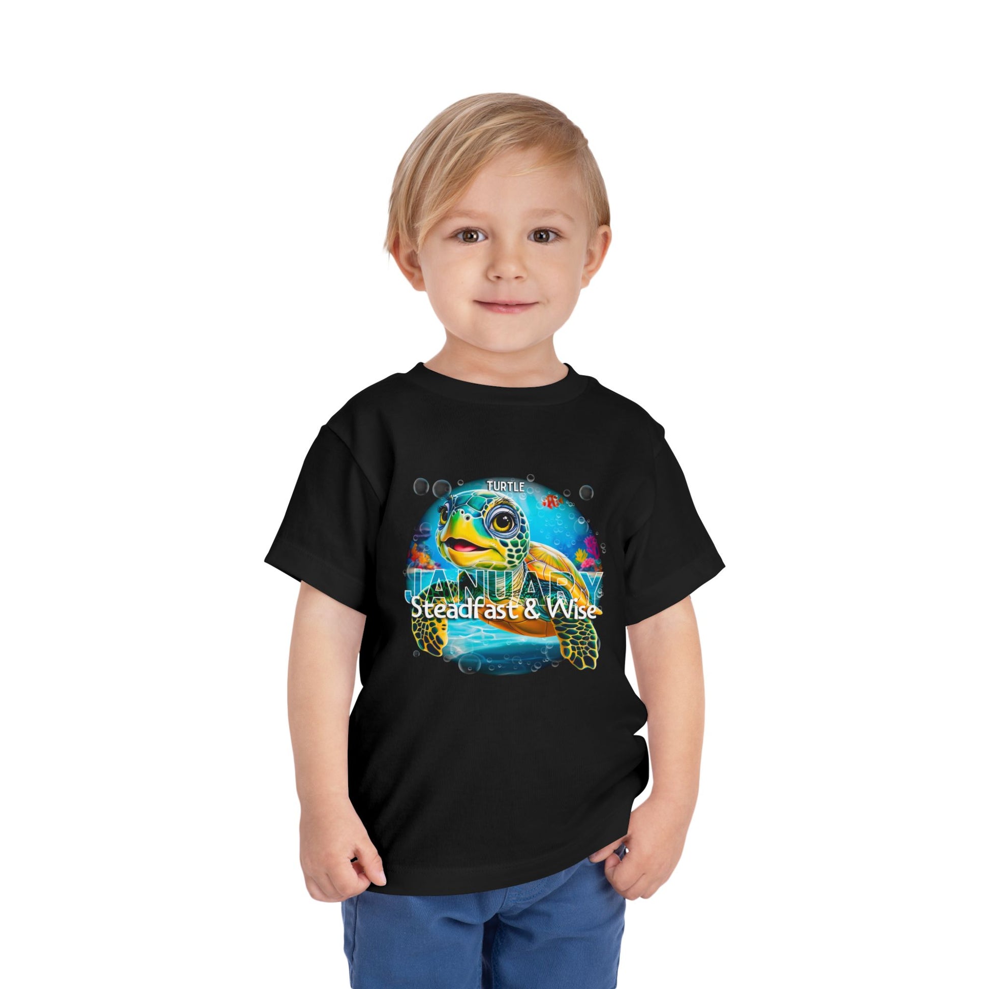Boy wearing black kids birth month tshirt with colorful sea turtle design for January 