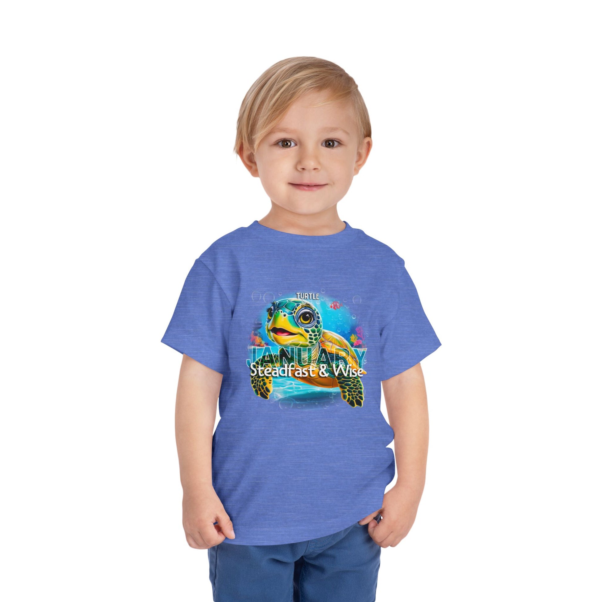 Boy wearing a blue kids birth month tshirt with a colorful turtle design labeled January