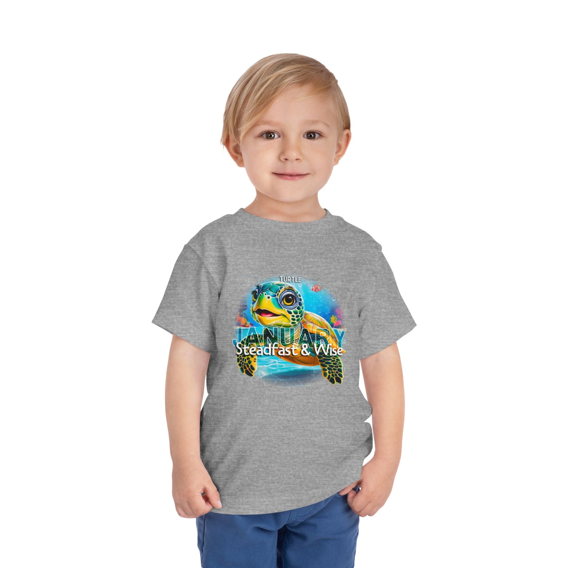 Child wearing a gray kids birth month tshirt with colorful January turtle design 