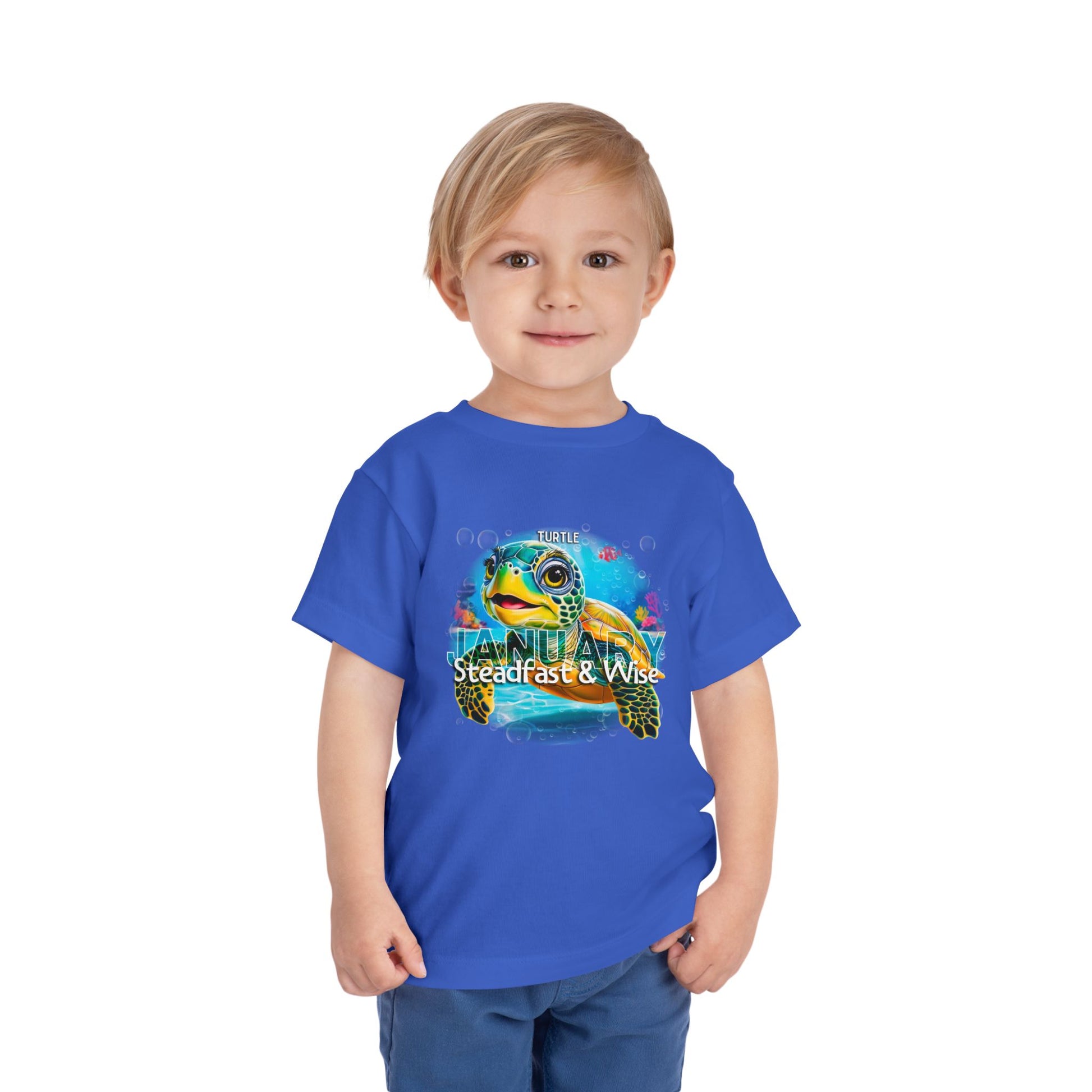 Toddler wearing blue kids birth month tshirt featuring a colorful turtle design for January
