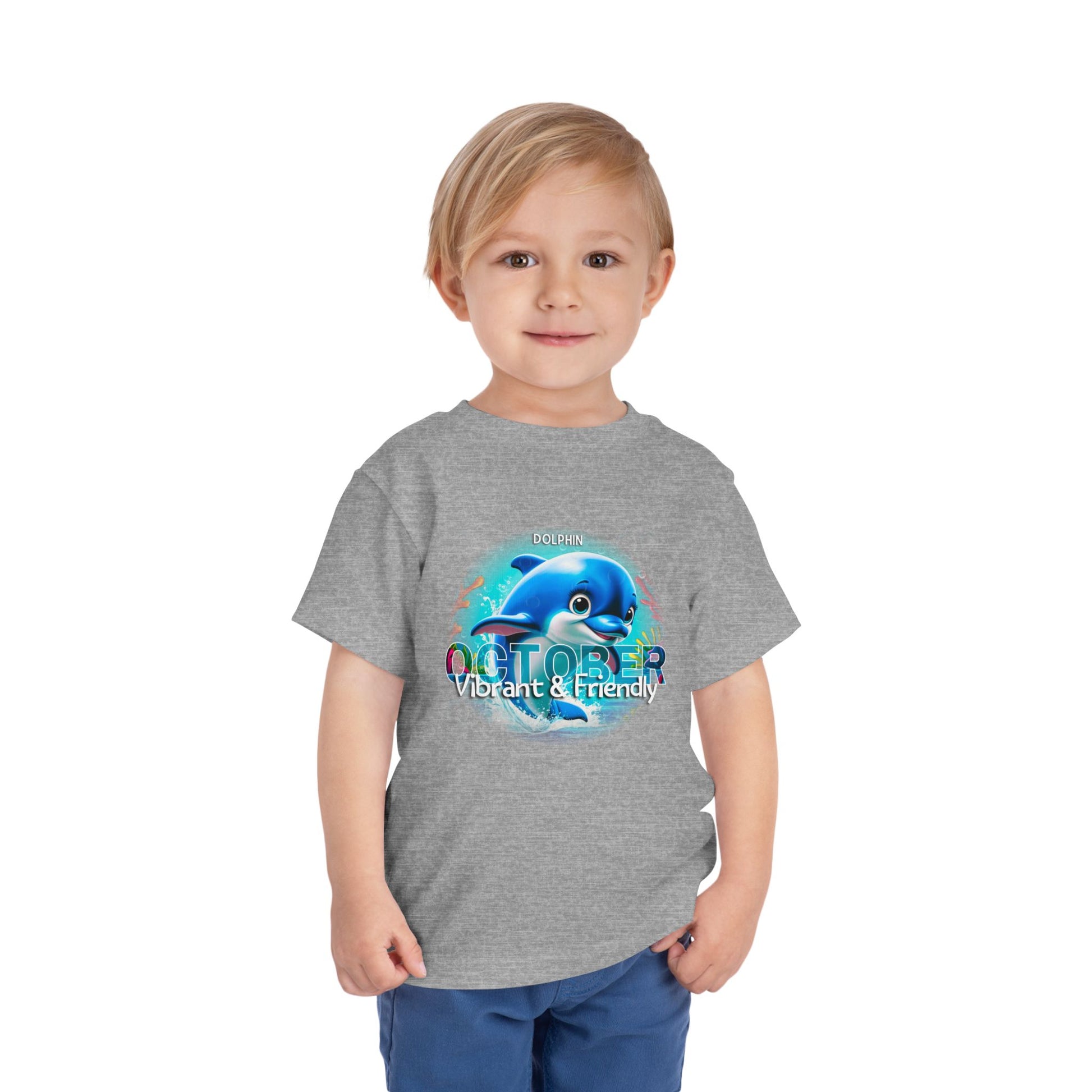 Child wearing a gray kids birth month tshirt with a blue dolphin and October design 