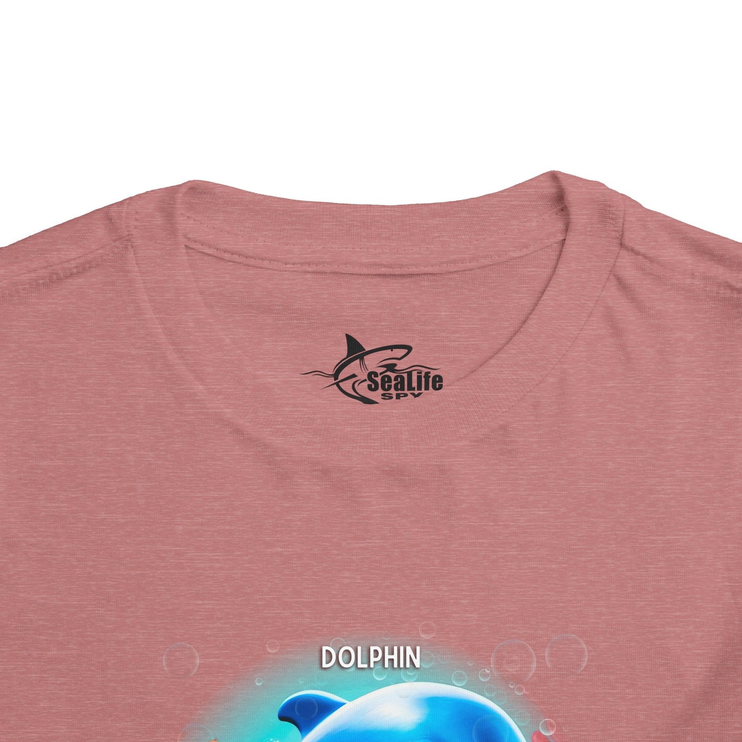 Kids birth month tshirt with dolphin graphic on pink fabric close up