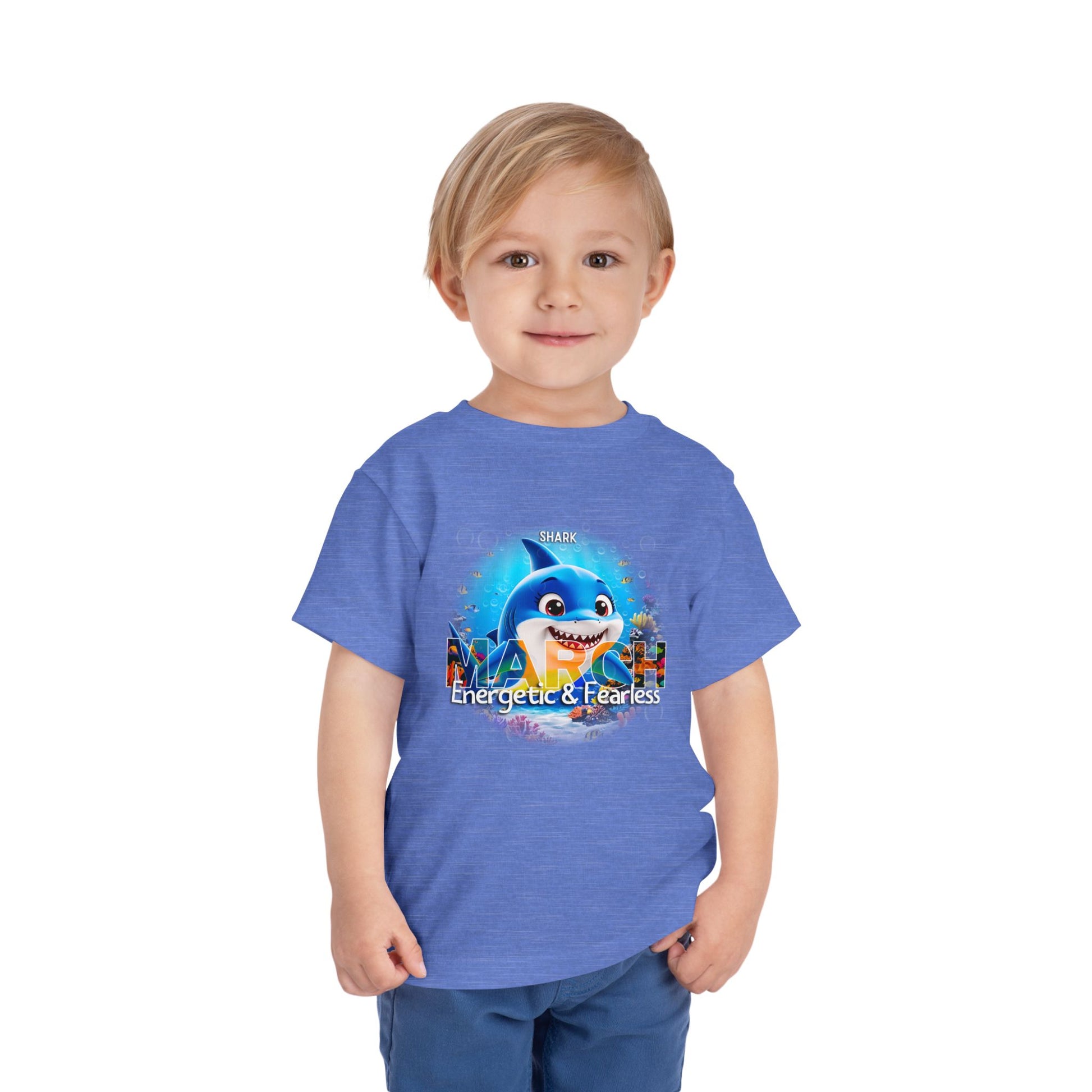 Toddler wearing blue kids birth month tshirt featuring March shark design with energetic and fearless text