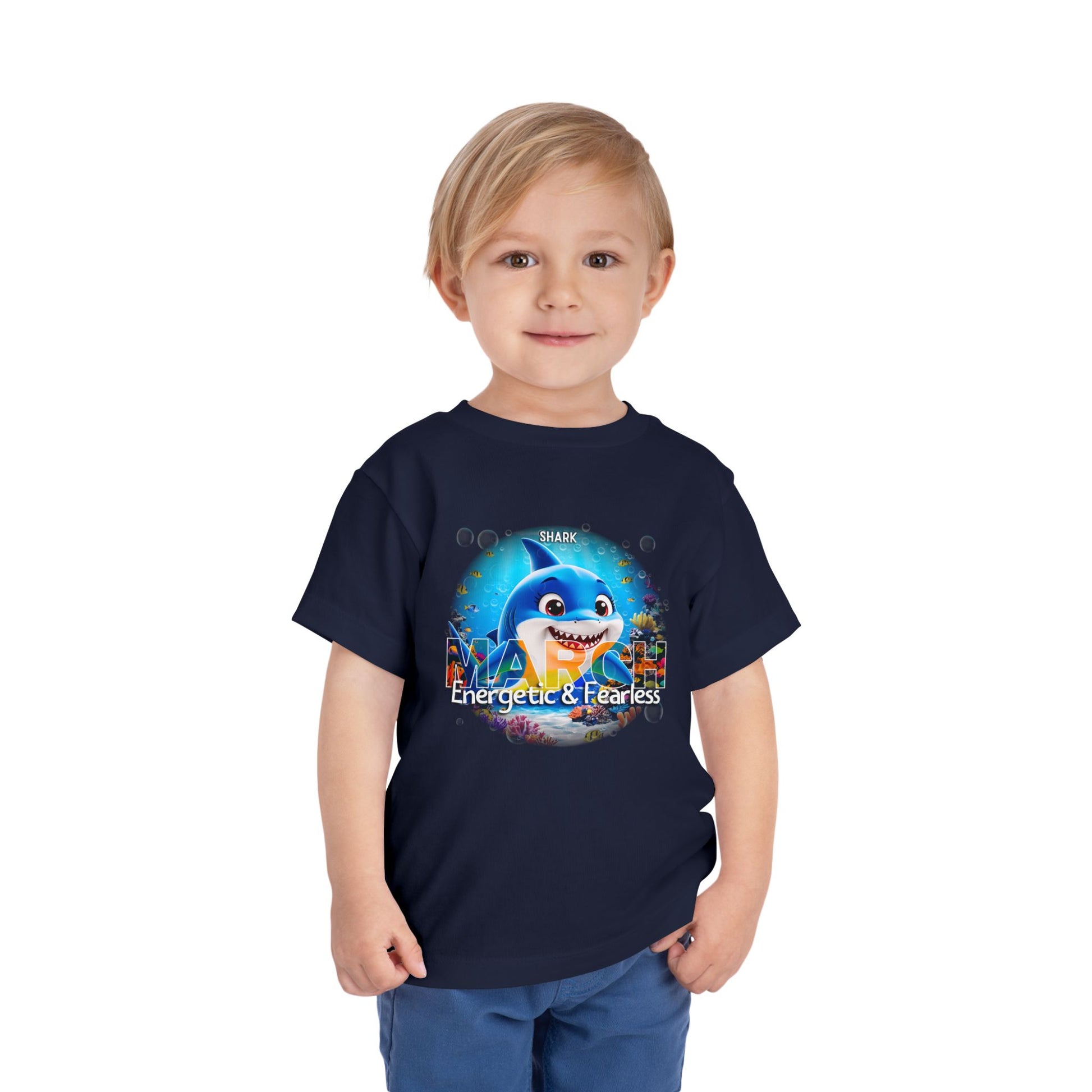 Boy wearing navy kids birth month tshirt featuring March shark design with energetic and fearless text