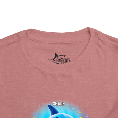 Kids birth month tshirt with colorful shark design on pink fabric close up