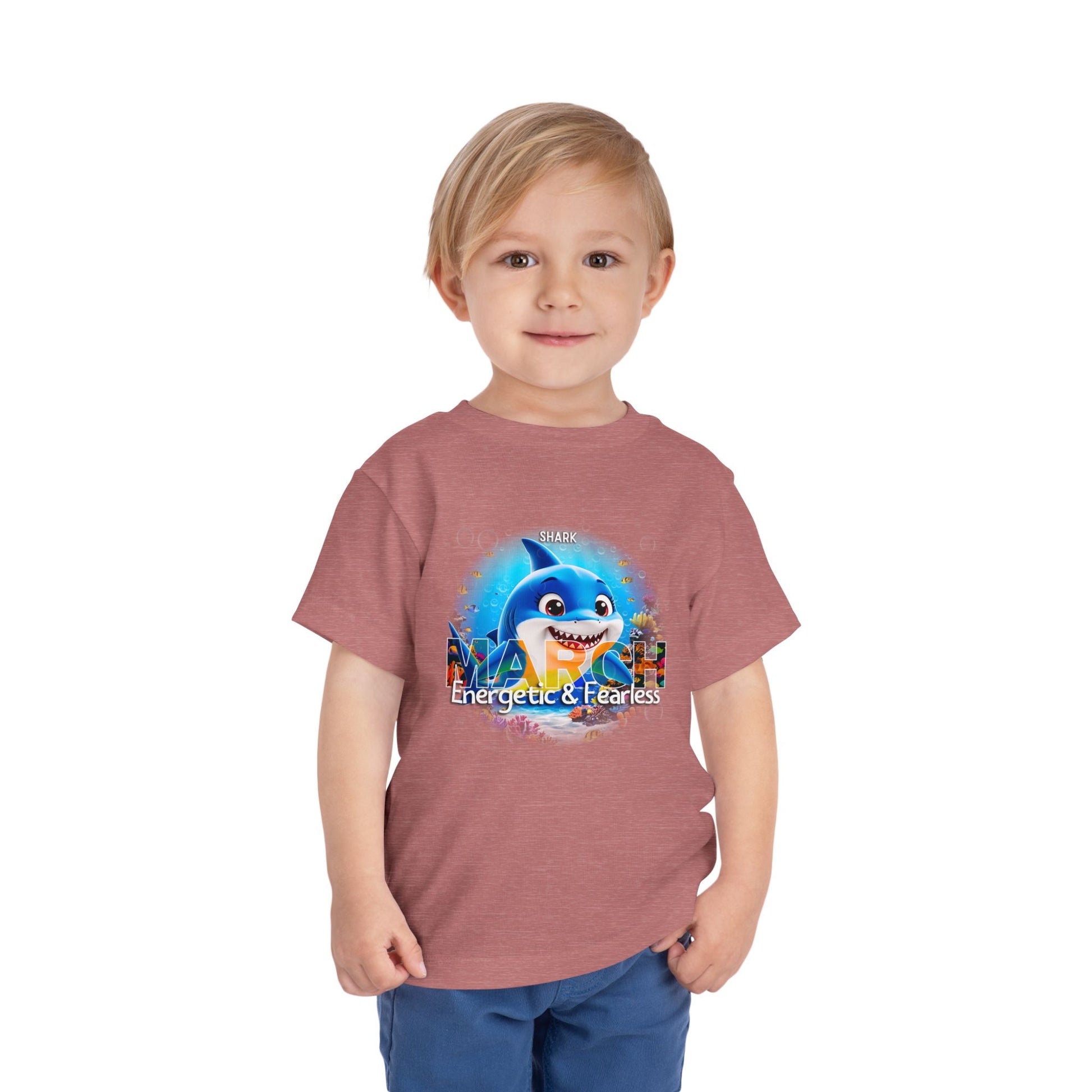 Toddler wearing a kids birth month tshirt featuring a March shark design with energetic and fearless text