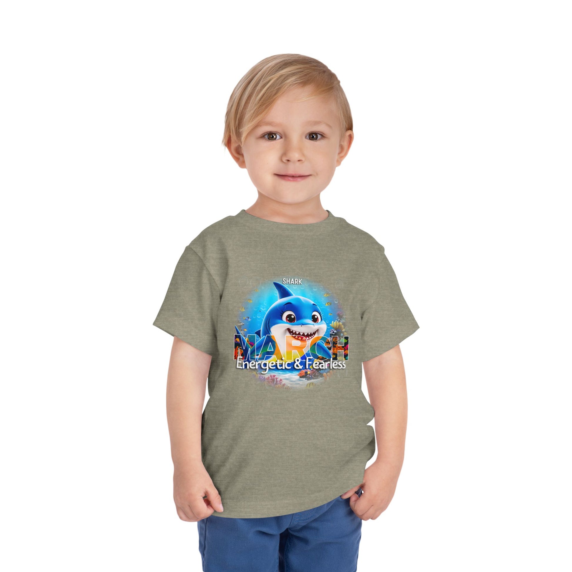 Kids birth month tshirt with energetic and fearless shark design worn by smiling toddler boy