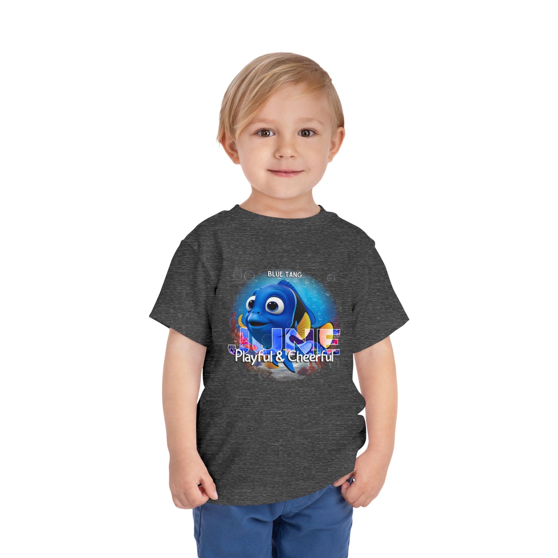 Kids birth month tshirt featuring playful blue tang graphic on dark gray shirt