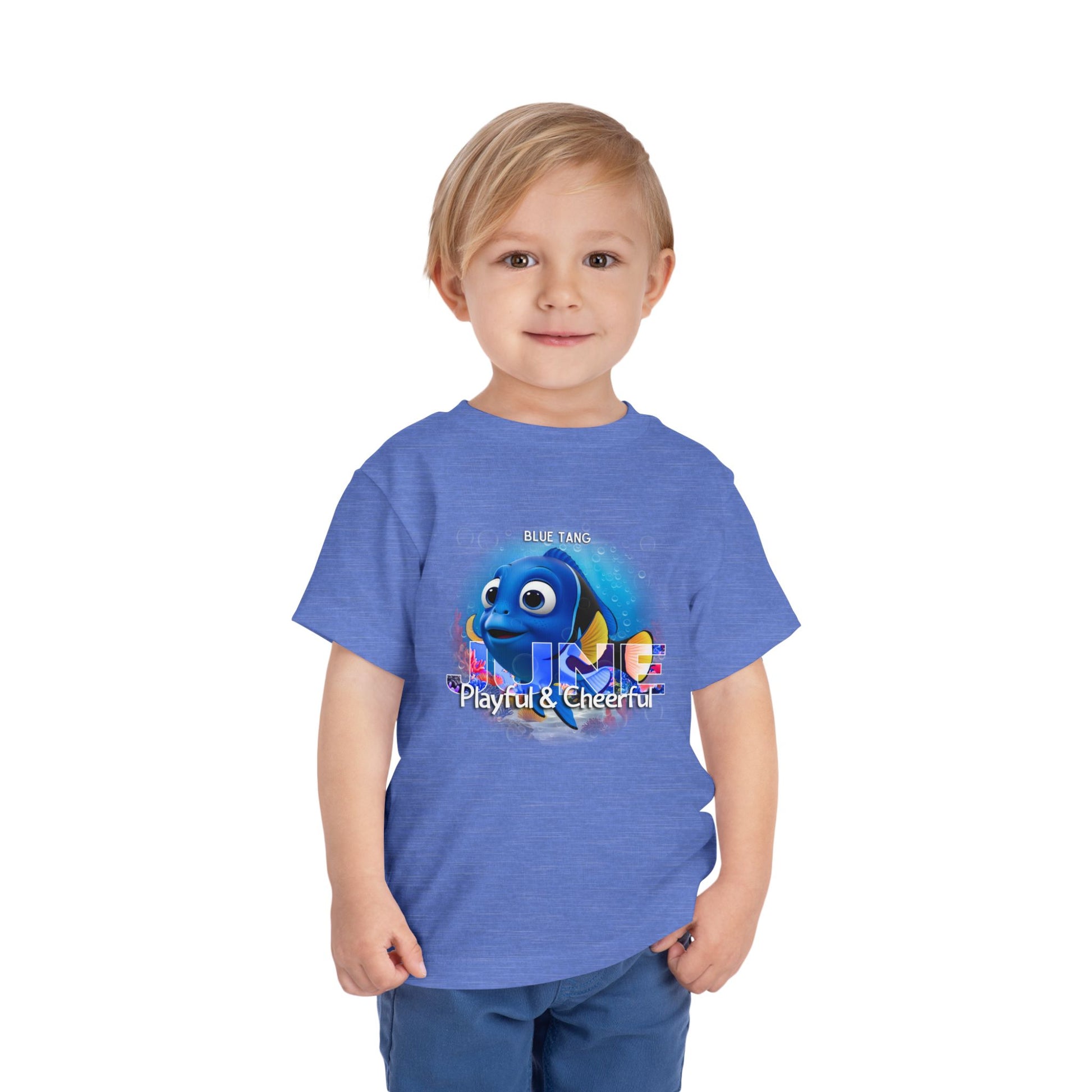 Kids birth month tshirt with playful blue tang graphic on blue shirt worn by young boy
