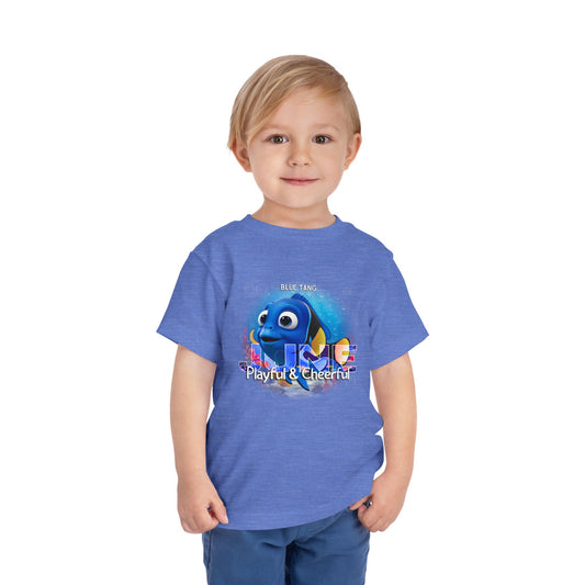 Kids birth month tshirt with playful blue tang graphic on blue shirt worn by young boy
