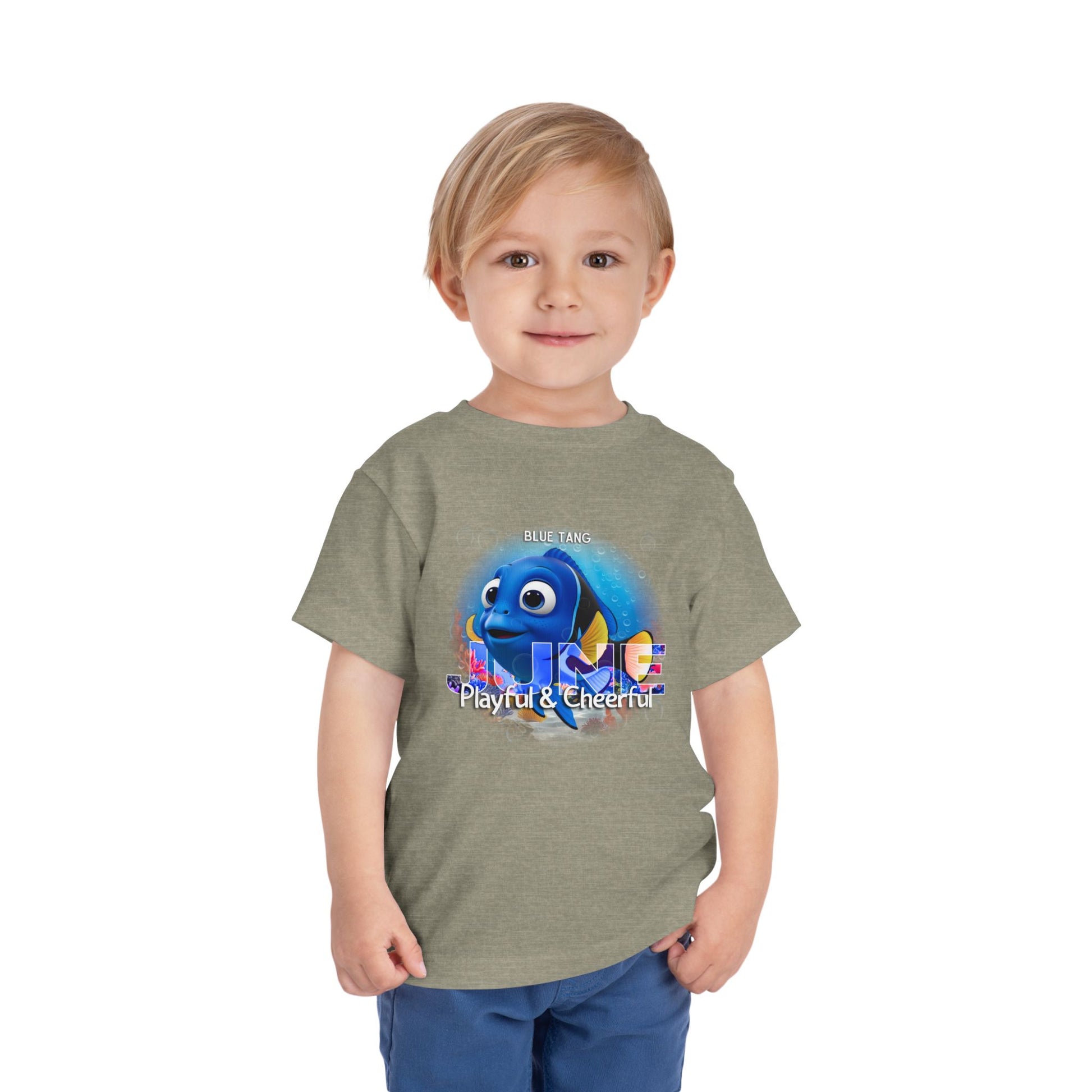 Toddler wearing kids birth month tshirt with blue tang fish graphic and playful cheerful text