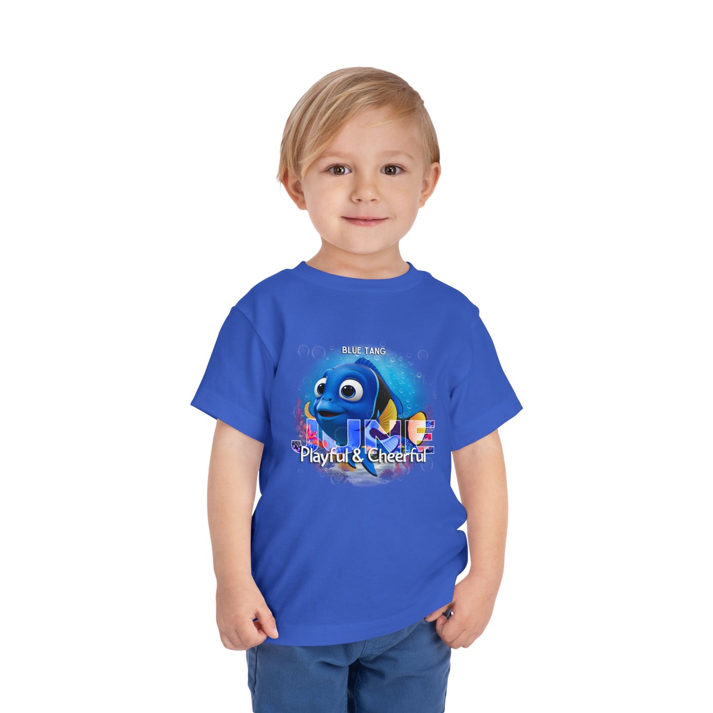 Toddler wearing blue kids birth month tshirt featuring a playful blue tang fish graphic 