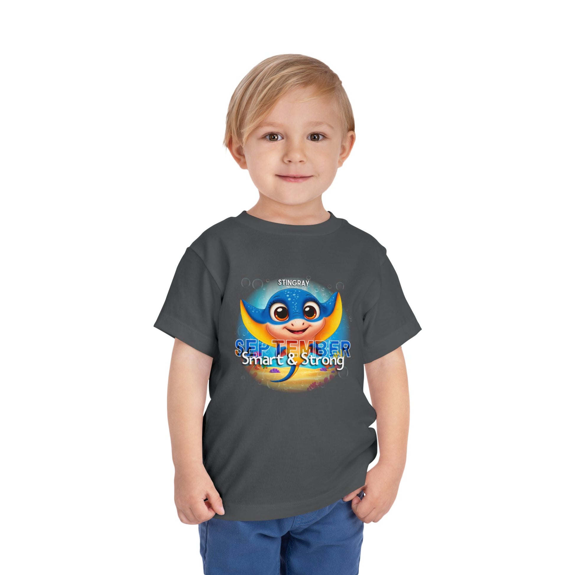 Young boy wearing kids birth month tshirt with September stingray design and smart strong text