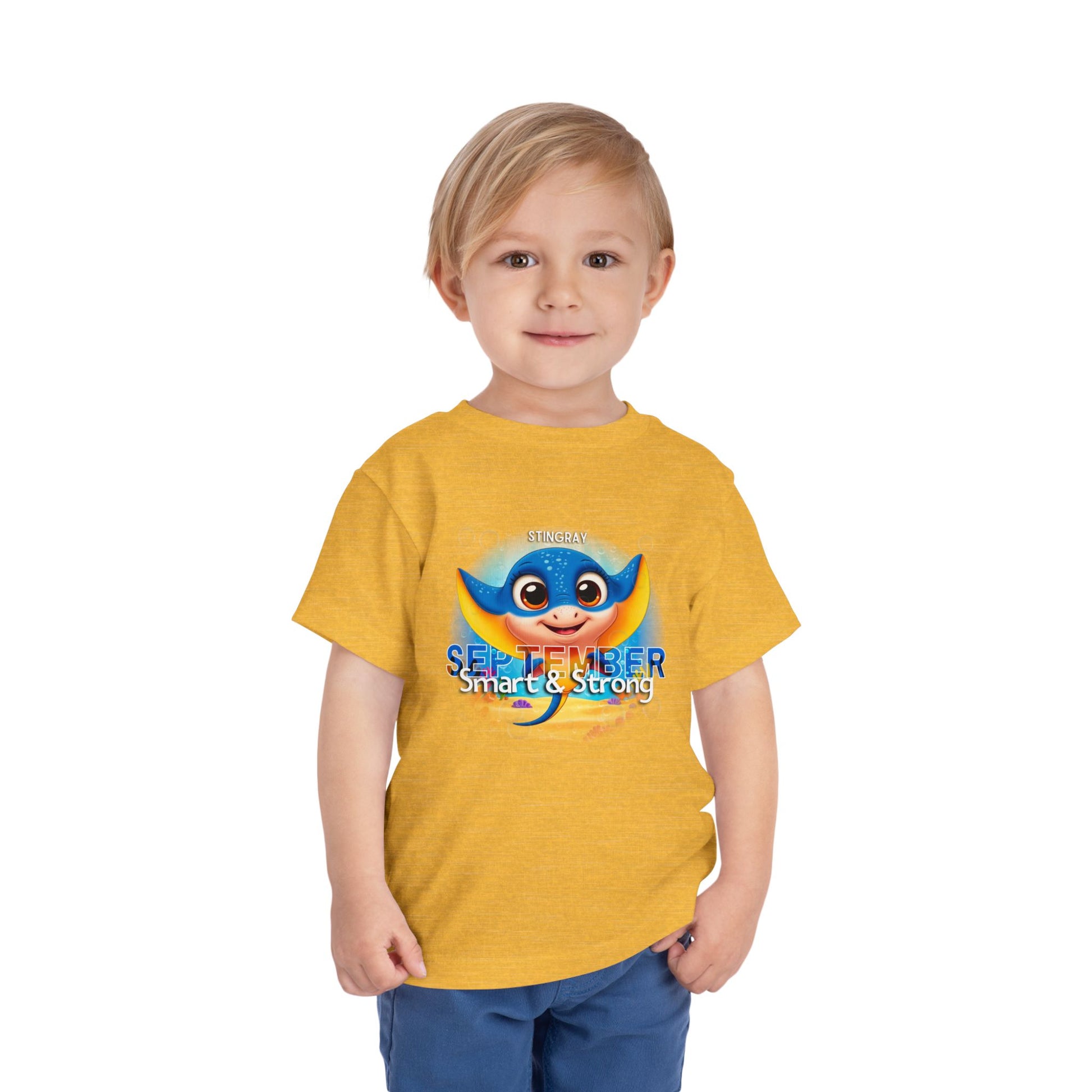 Toddler wearing yellow kids birth month tshirt with blue stingray graphic for September