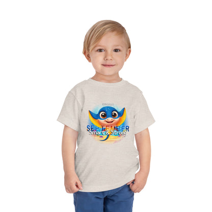 Toddler wearing a September kids birth month tshirt featuring a colorful superhero character and text