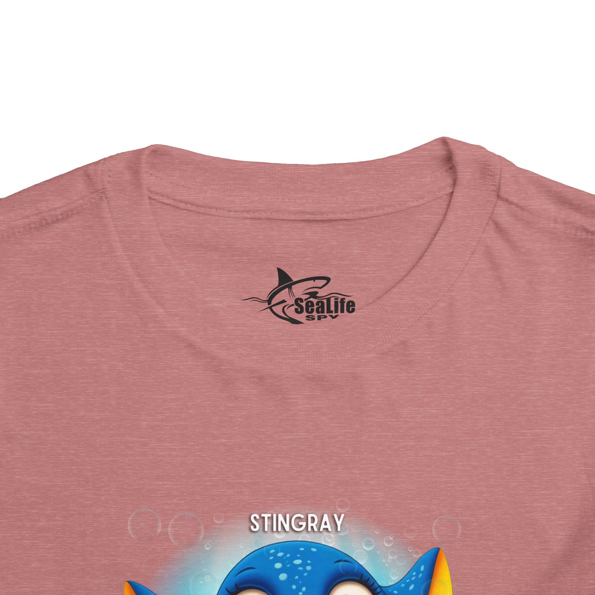 Kids birth month tshirt with colorful stingray graphic on a pink fabric background