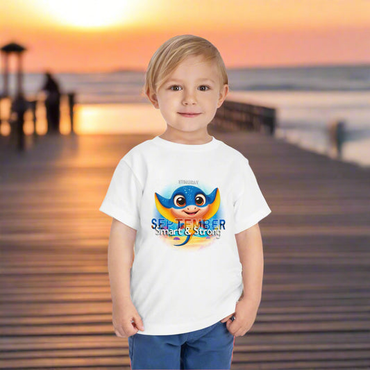 Toddler wearing kids birth month tshirt with colorful September design and ocean background