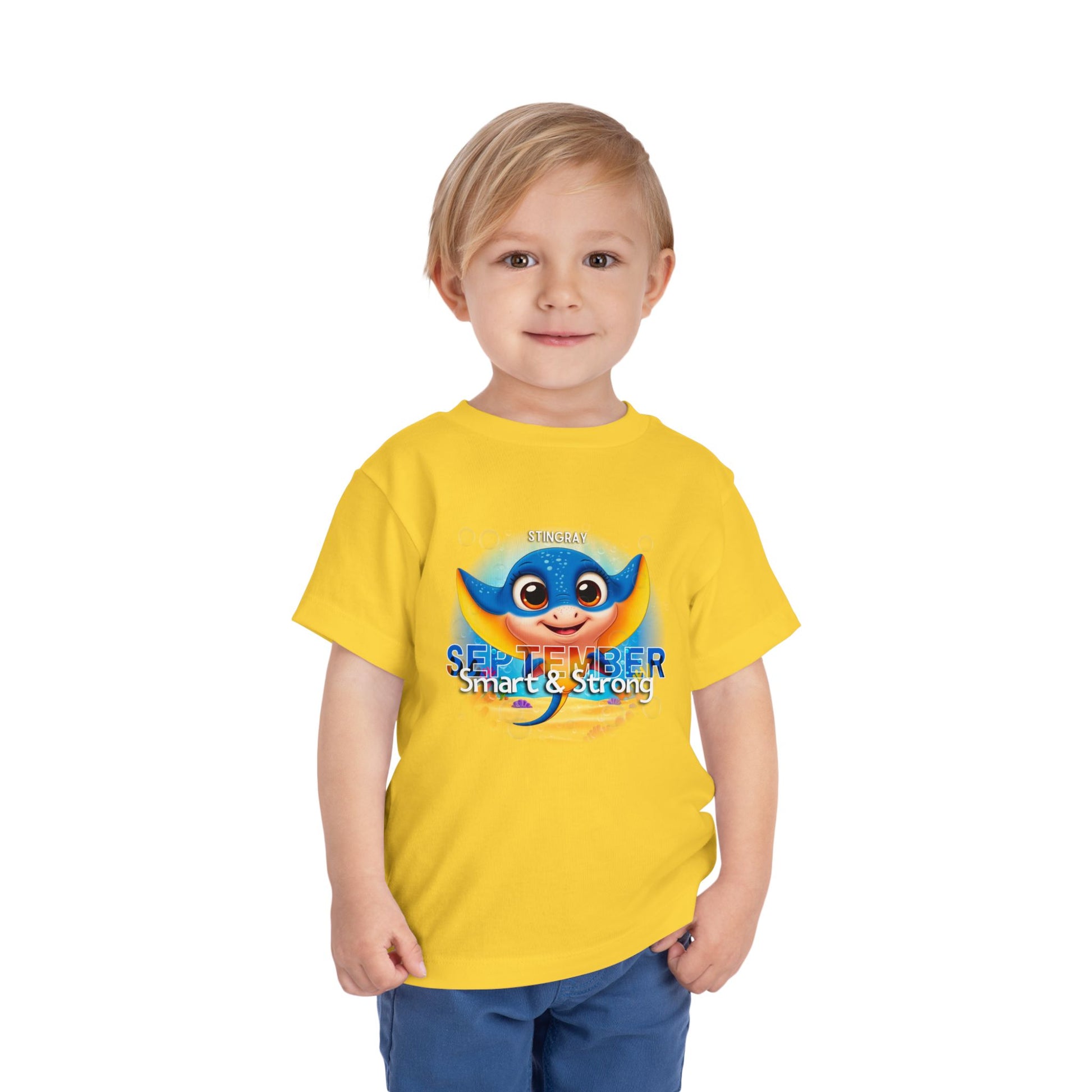 Toddler wearing yellow kids birth month tshirt with blue stingray design for September