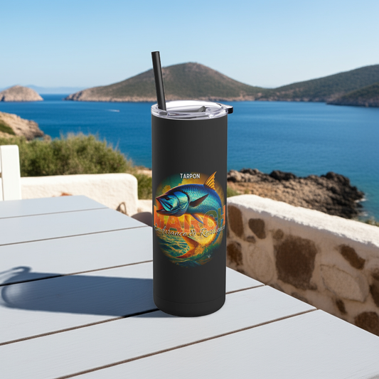 Black birth month travel tumbler with colorful tarpon fish design on outdoor table near ocean